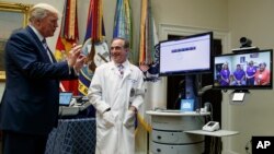 Presiden AS Donald Trump berbicara lewat televideo dengan para pasien didampingi Menteri urusan Veteran David Shulkin (baju putih), di Gedung Putih, Kamis (3/8). 