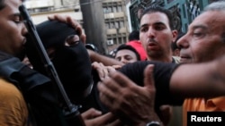 Egyptian forces member moves through crowd of interim government supporters near al-Fath mosque, Cairo, Aug. 17, 2013.