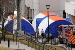 Officials from hospital support services talk outside negative pressure screening tents set up outside the emergency room entrance at University of Utah hospital as they prepare for coronavirus testing, in Salt Lake City, Utah, March 9, 2020.