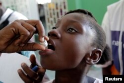 A girl receives an oral cholera vaccine at the Immaculate Conception Hospital in Les Cayes, Haiti, Nov. 8, 2016.