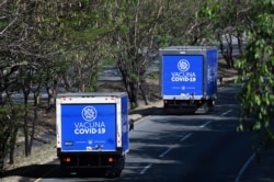 FILE - Trucks carrying Chinese Sinovac's CoronaVac vaccines against the COVID-19 disease leave the San Oscar Romero International Airport in San Luis Talpa, El Salvador, on March 28, 2021.