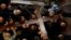 Worshippers carry a large wooden cross into the Church of the Holy Sepulchre during Good Friday procession along the Via Dolorosa in Jerusalem's Old City, April 19, 2019.