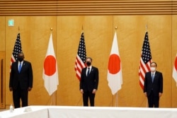 Japanese Prime Minister Yoshihide Suga, right, U.S. Secretary of State Antony Blinken, center, and U.S. Defense Secretary Lloyd Austin, left, pose for photo session during a courtesy call at the prime minister's official residence Tuesday, March 16, 2021.