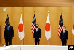 Japanese Prime Minister Yoshihide Suga, right, U.S. Secretary of State Antony Blinken, center, and U.S. Defense Secretary Lloyd Austin, left, pose for photo session during a courtesy call at the prime minister's official residence Tuesday, March 16, 2021.