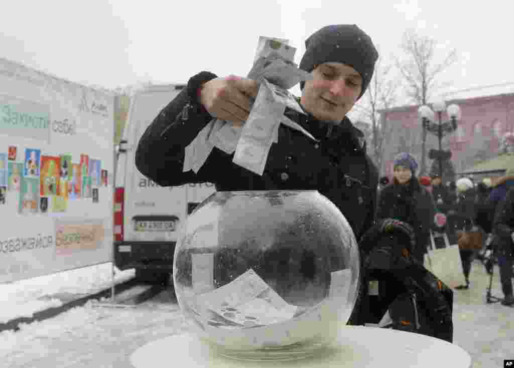 Seorang pria mengambil kondom gratis di pusat kota Kyiv, Ukraina (1/12). Para tenaga sukarela dari lembaga-lembaga swadaya masyarakat membagikan kondom untuk memperingati Hari AIDS Sedunia. (AP/Efrem Lukatsky)
