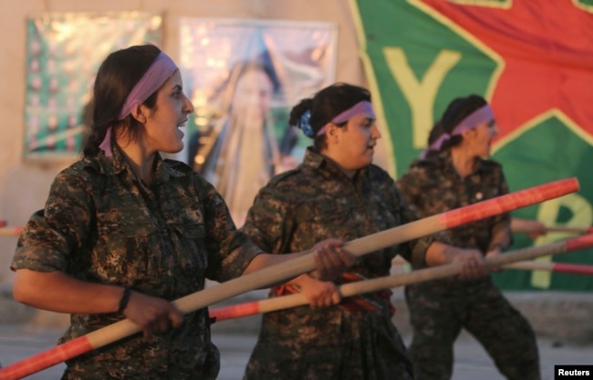 FILE - Kurdish female fighters of the Women's Protection Unit (YPJ) participate in training at a military camp in Ras al-Ain city in Syria's Hasakah province June 30, 2014.
