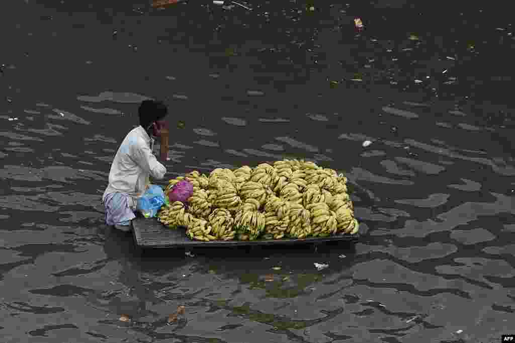 A fruit vendor pushes his cart through a flooded street after a heavy rainfall in Lahore, Pakistan.
