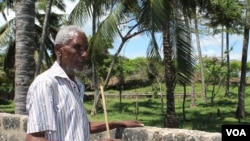 Piry Muye stands beside a stone wall fencing off the land that was once his, Mombasa, Kenya, November 18, 2012. (H. Heuler/VOA)