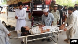 Pakistanis shift an injured bomb blast victim into a hospital in Kohat, July 18, 2012. 