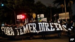 Demonstrators protest holding a banner that reads in Portuguese "Get out Temer, elections now," outside the residence of Brazil's President Michel Temer during a general strike in Sao Paulo, Brazil, April 28, 2017. 