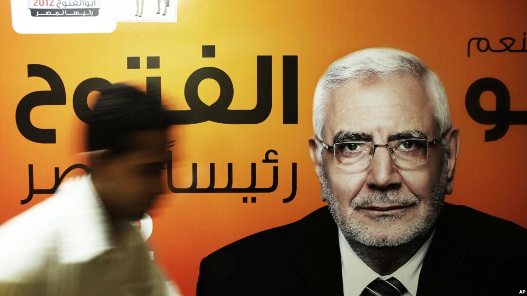 Pada foto 19 Mei 2012,seorang petugas kampanye berjalan di depan poster kandidat presiden Mesir, Abdel-Monaem Abul Fetouh di markasnya di Kairo, Mesir. Abdel-Monaem ditahan pada 15 Februari 2018 karena diduga berhubungan dengan Kelompok Persaudaraan Muslim yang terlarang.