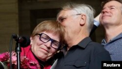 Lee Carter, whose mother had challenged Canada's assisted-suicide ban and traveled to Switzerland to end her life in 2010, embraces her husband, Hollis Johnson, while speaking to journalists at the Supreme Court of Canada in Ottawa, Feb. 6, 2015.