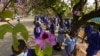 Schoolchildren wait to enter their school in Harare, Zimbabwe, Monday Sept, 28, 2020. Zimbabwe schools have reopened in phases, but with smaller number of pupils, more teachers and other related measures to enable children to resume their education withou