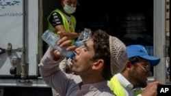 A Muslim pilgrim drinks water distributed by Saudi volunteers near the Grand Mosque, ahead of the annual Hajj pilgrimage, in the Muslim holy city of Mecca, Saudi Arabia, Aug. 18, 2018.
