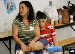 Recent transplant from Puerto Rico, Arieliss Valencia sits next to her son Anthony, a fifth grader at Riverdale Elementary School in Orlando, Fla. Anthony left Puerto Rico with his family after Hurricane Maria destroyed his home.