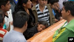 A girl embraces the coffin with the body of Yalid Jimenez, 29, who died Sunday during the clearing of the highway in Nochixtlan, Mexico, June 20, 2016. Violence erupted during the weekend in confrontations between the police and striking teachers.