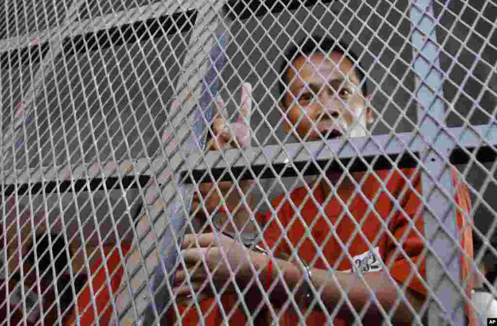 One of the 23 anti-government protesters who had been in prison since being arrested in January flashes a victory sign on his arrival at Phnom Penh Municipality Court, Cambodia, May 30, 2014.