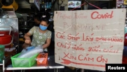 Một cửa hàng với biển báo mua đồ mang đi và nhắc người mua giãn cách nhau 2m trong lúc dịch bùng phát trong cộng đồng ở Hà Hội hôm 31/5. Việt Nam cho biết sẽ nhận được 1 triệu liều vaccine chống COVID-19 của AstraZeneca mỗi tuần từ tháng 7.