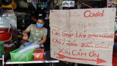 Một cửa hàng với biển báo mua đồ mang đi và nhắc người mua giãn cách nhau 2m trong lúc dịch bùng phát trong cộng đồng ở Hà Hội hôm 31/5. Việt Nam cho biết sẽ nhận được 1 triệu liều vaccine chống COVID-19 của AstraZeneca mỗi tuần từ tháng 7.