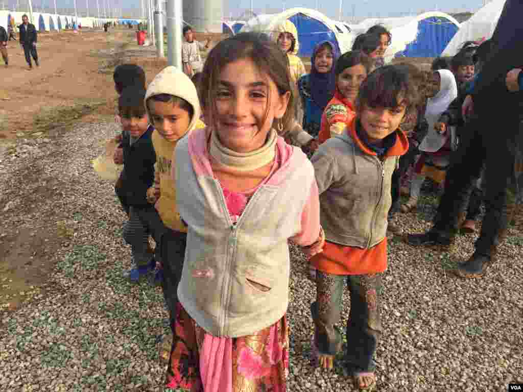 Little girls here in Khazir Camp, Kurdish Iraq say they like to pretend camp workers are giving them papers to get supplies like food and fuel on Dec. 1, 2016. (H.Murdock/VOA)