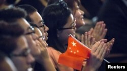 FILE - Students clap while Chinese President Xi Jinping delivers a speech during a visit to Lincoln High School in Tacoma, Washington, Sept. 23, 2015. 