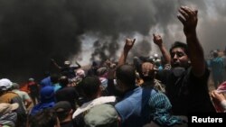 Para demonstran Palestina memrotes pemindahan Kedutaan Besar AS ke Yerusalem, dalam aksi di perbatasan Gaza-Israel, Senin (14/5). 