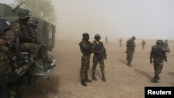 Des soldats camerounais de la Brigade d'intervention rapide montent la garde au milieu de la poussière soulevée par un hélicoptère en Kolofata, le Cameroun, le 16 Mars 2016 REUTERS / Joe Penney 
