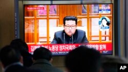 People watch a TV showing a file image of North Korean leader Kim Jong Un shown during a news program at the Seoul Railway Station in Seoul, South Korea, Jan. 20, 2022.