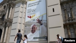 People walk past Lima Cathedral with a banner of Pope Francis before his visit to Peru, Jan. 18-21, in Lima, Peru, Jan. 12, 2018.