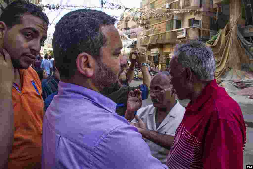 Residents of Azareta in Alexandria gathered to watch the demolitions process and talking about their fear from the possibly collapse of the rest of the buildings in the neighbourhood. Sunday, June 4, 2017. (H. Elrasam/VOA)