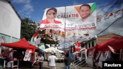 Un hombre arregla una pancarta de la candidata presidencial del Partido Libre, Xiomara Castro, antes de las elecciones generales, en Tegucigalpa, Honduras, el 27 de noviembre de 2021. REUTERS / Fredy Rodríguez