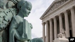 FILE - A cherub holding an open book adorns a flagpole on the plaza of the Supreme Court in Washington, April 4, 2016. 