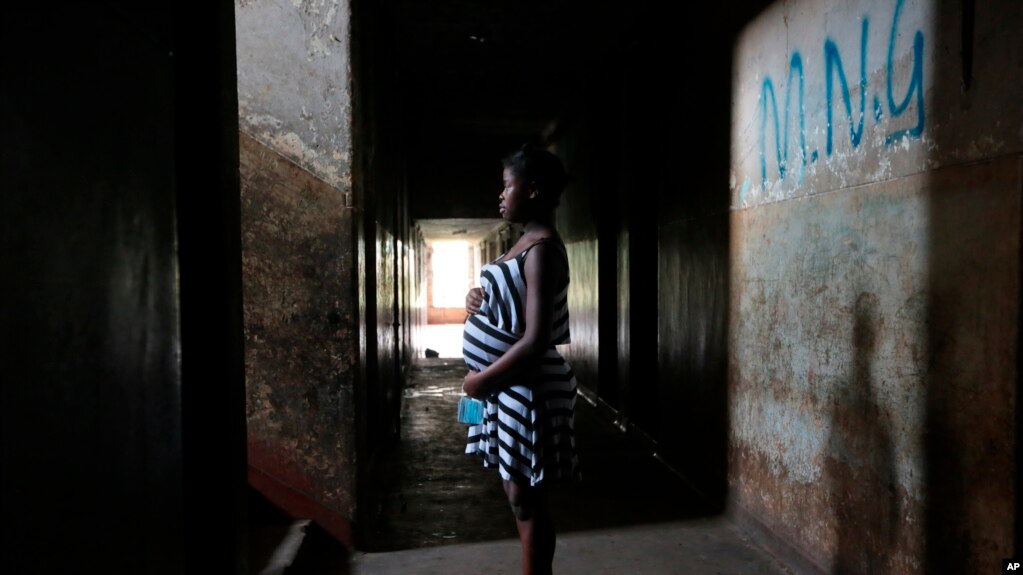 Tanaka Rwizi, a pregnant 16 year old teenager mother, stands in the hallway of her residence in the poverty stricken Mbare township in Harare, Zimbabwe, Saturday Nov. 13, 2021. (AP Photo/Tsvangirayi Mukwazhi)