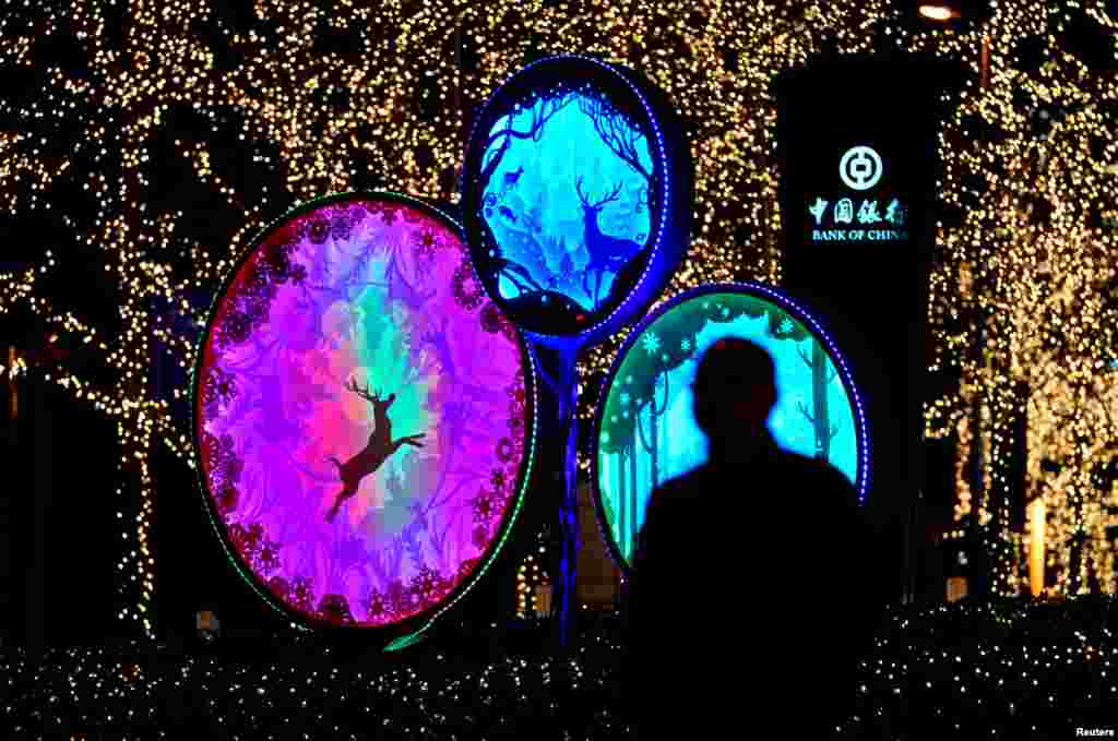 A man walks past Christmas decorations outside China World Trade Center Tower III in Beijing, China.