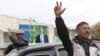 Local residents gesture, with a poster displaying Kyrgyzstan's Prime Minister and presidential candidate Almazbek Atambayev, in the village of Arashan outside the capital Bishkek October 26, 2011. Twenty candidates will vie for the presidency of Kyrgyzsta