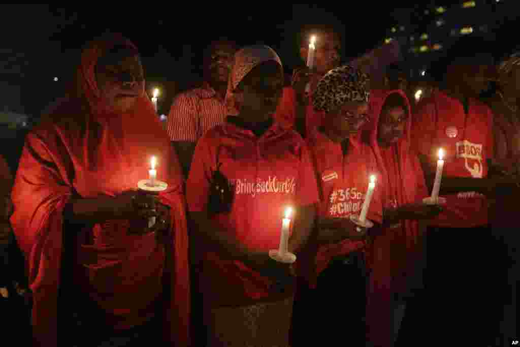 Warga memegang lilin dalam doa bersama untuk menandai satu tahun diculiknya siswi-siswi SMP Negeri di Chibok, Abuja, Nigeria. (AP/Sunday Alamba)