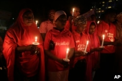 FILE - People hold candles during a vigil to mark the one year anniversary of the abduction of girls studying at the Chibok government secondary school, Abuja, Nigeria, April 14, 2015.
