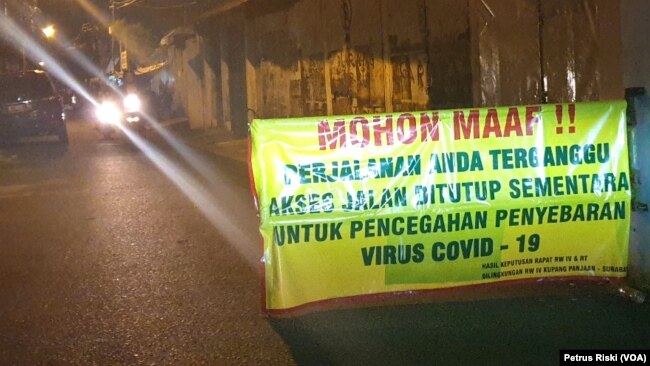 Salah satu kampung di Surabaya memasang portal jelang PSBB, yang membatasi keluar masuknya warga untuk mencegah penyebaran virus corona, Sabtu, 25 April 2020. (Foto: Petrus Riski/VOA)
