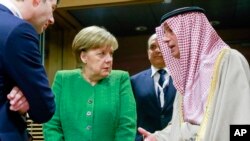FILE - German Chancellor Angela Merkel, center, speaks with Saudi-Arabia's Foreign Minister Adel al-Jubeir, right, during a round table meeting of the EU-Sahel at EU headquarters in Brussels.