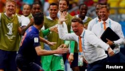 Robin van Persie merayakan gol dengan pelatih Belanda Louis van Gaal di Salvador, Brazil (13/6).