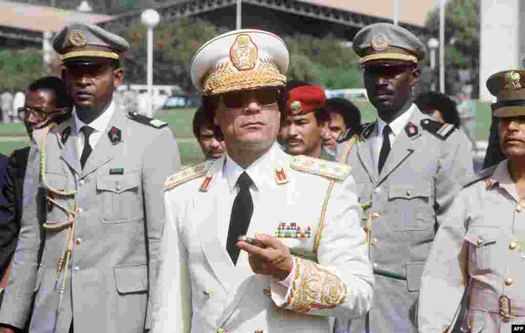 Libyan Head of State Colonel Moammar Gadhafi (C) reviews troops 03 December 1985 in Dakar upon his arrival for three-day official visit to Senegal, (AFP).