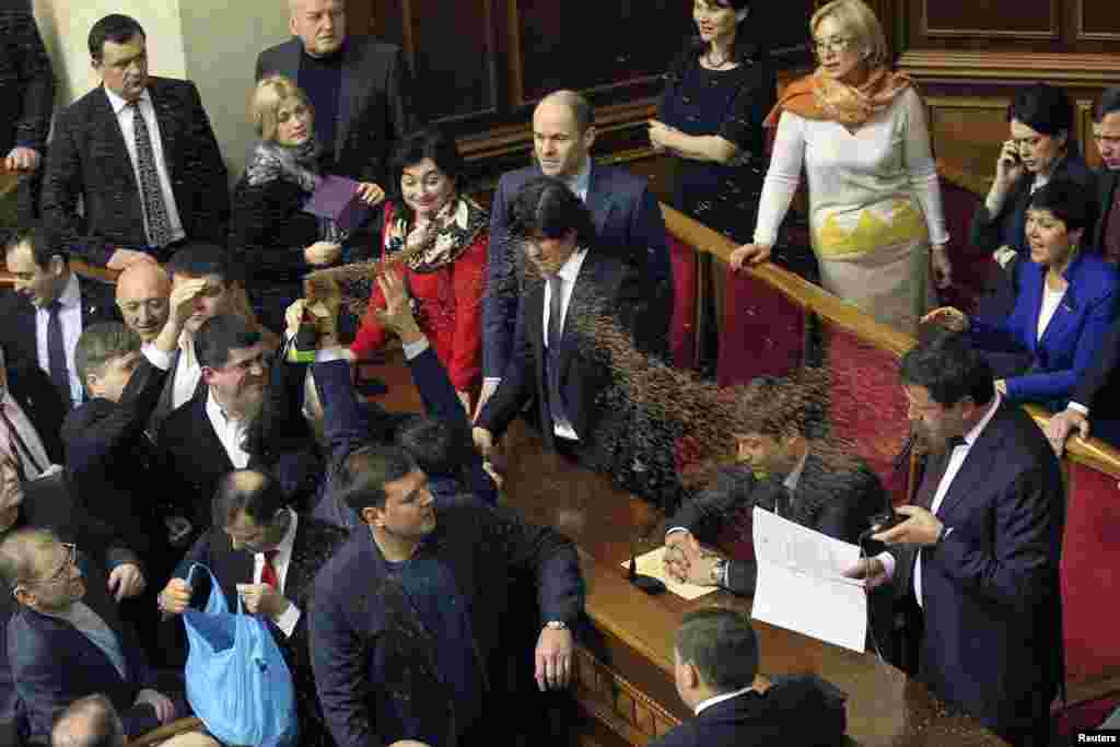 Opposition deputies throw buckwheat at newly elected deputy Viktor Pylypyshyn (R) as he takes the oath in Ukrainian Parliament in Kyiv. In Ukraine, buckwheat is a symbol of bribing voters.