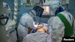 Medicinski radnici pomažu zaraženom od koronavirusa, u Zemunskoj bolnici u Beogradu, 26. novembra 2020. (Foto: Reuters/Marko Đurica)