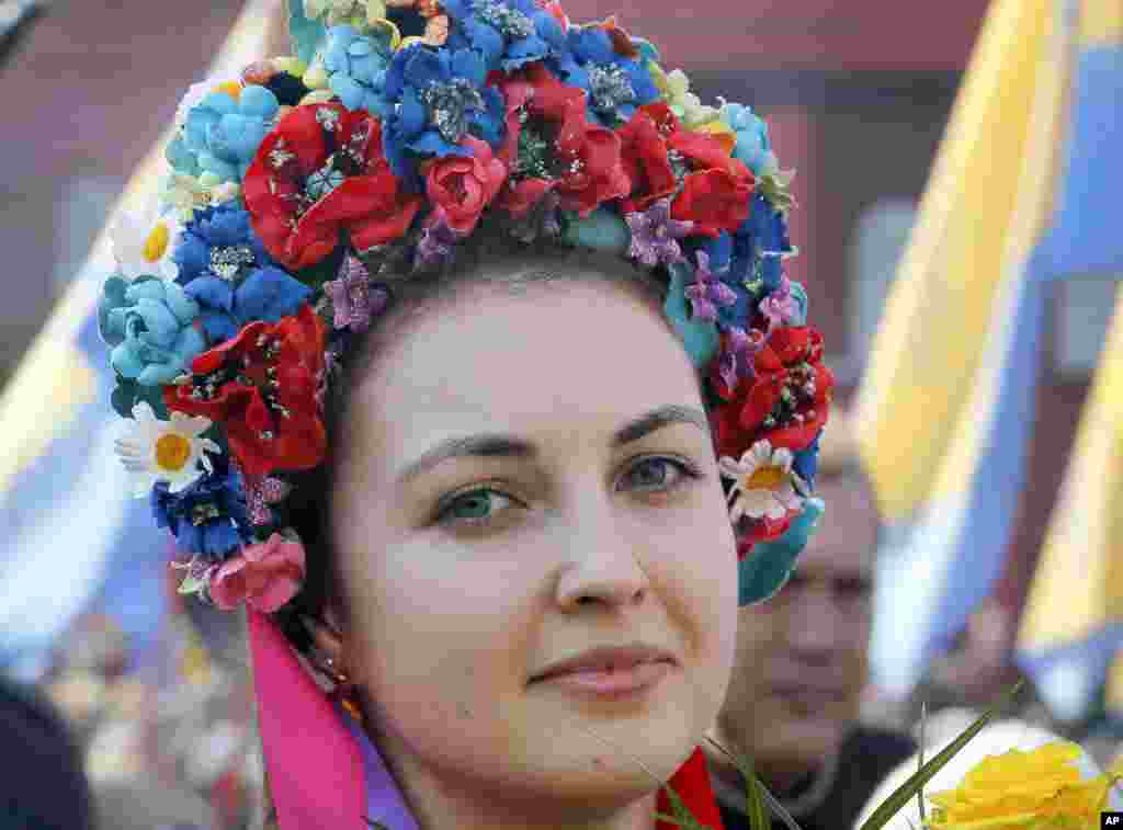 A Ukrainian woman, dressed in traditional embroidered clothing, attends an event at a monument to the revered national poet Taras Shevchenko marking the 203th anniversary of his birth, in Kyiv.