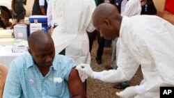 Nhân viên y tế tiêm vaccine Ebola cho người dân ở Conakry, Guinea, ngày 7/3/2015.