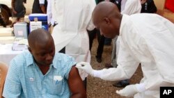 Un agent de la santé se prépare à injecter le vaccin expérimental à un homme à virus Ebola à Conakry, Guinée, le 7 mars 2015.