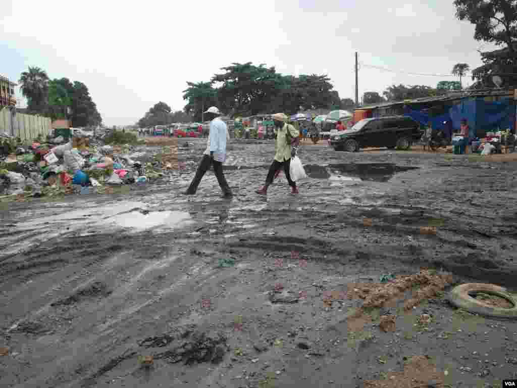 Angola, Luanda. Moradores caminham entre a lama e o lixo, consequência das chuvas que se fazem sentir há mais de uma semana. 25 de Abril 2014