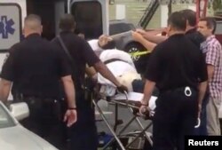 A policeman takes a photo of a man they identified as Ahmad Khan Rahami