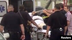 A policeman takes a photo of a man they identified as Ahmad Khan Rahami