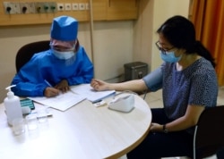 Seorang petugas kesehatan memeriksa kesehatan relawan dalam simulasi untuk uji klinis vaksin virus corona di Fakultas Kedokteran Universitas Padjajaran, Bandung, Jawa Barat, 6 Agustus 2020. (Foto: Reuters)